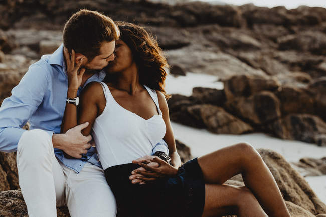 Portrait d'un couple qui s'embrasse avec le photographe sur une plage près de Brest