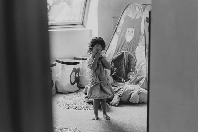la grande soeur du bébé dans sa chambre en bretagne pose pour le photographe
