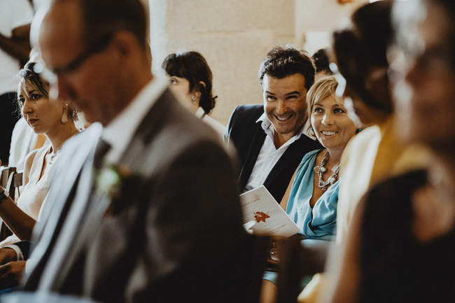 les invités du mariage sourient au photographe