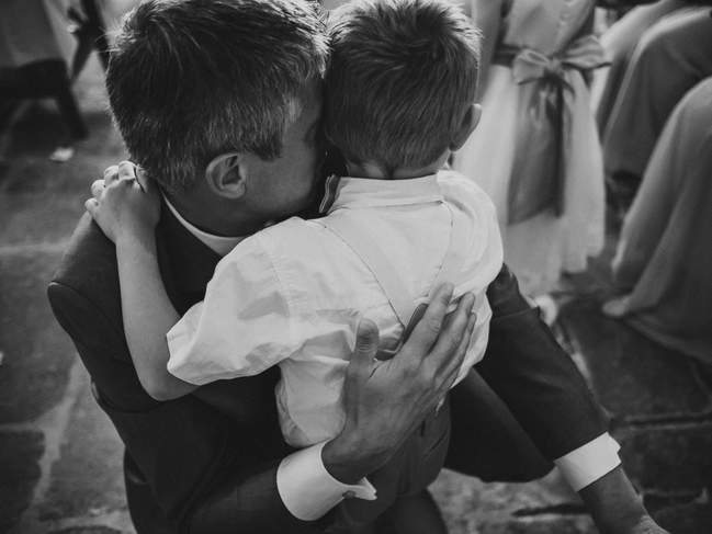 un papa embrasse sont fil sous les yeux du photographe