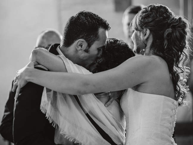 le marié embrasse sa mère pendant que le photographe les photographie